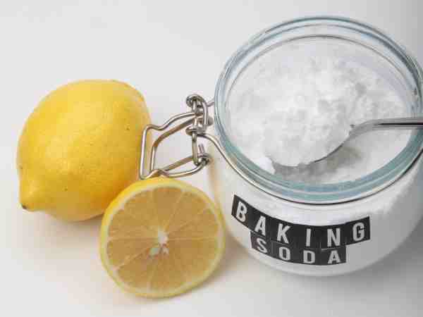 Baking soda, a whole lemon, and a lemon slice suggest eco-friendly cleaning for a healthy home.